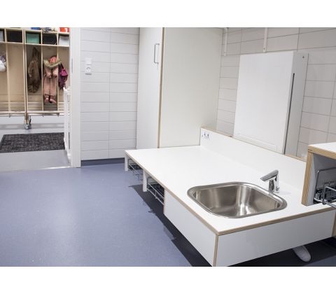 CE-mærket puslebord til institutioner 1400 x 900 mm fra ST Skoleinventar, inkl trådløs fjernbetjening og underlimet vask til højre